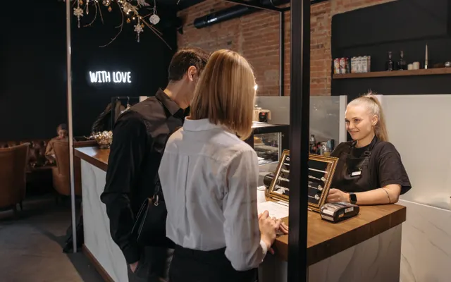 Atendimento a clientes no balcão de uma cafeteria.