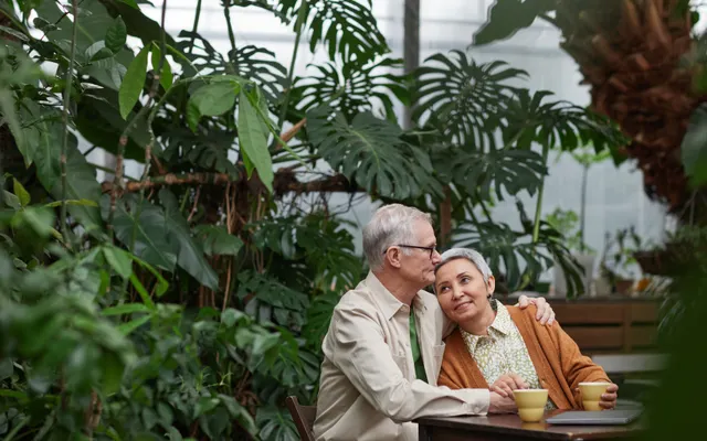 Casal mais velho compartilhando um momento em um jardim.