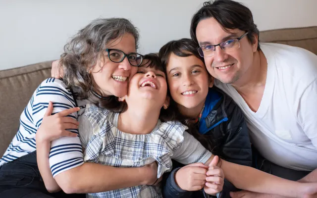Família reunida no sofá de casa.